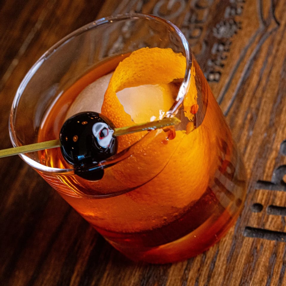 Old Fashioned cocktail with orange peel and cherry on the Crazy Good Barbeque bar.